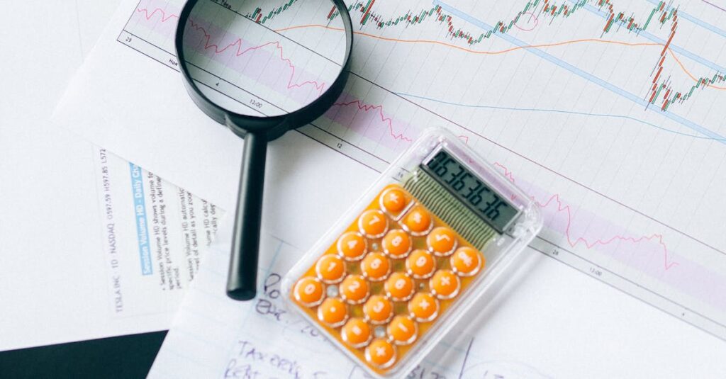 Top view of financial documents with calculator and magnifying glass, displaying charts and data analysis.